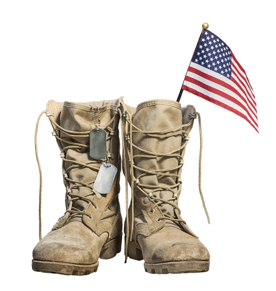 Old military combat boots with the American flag and dog tags